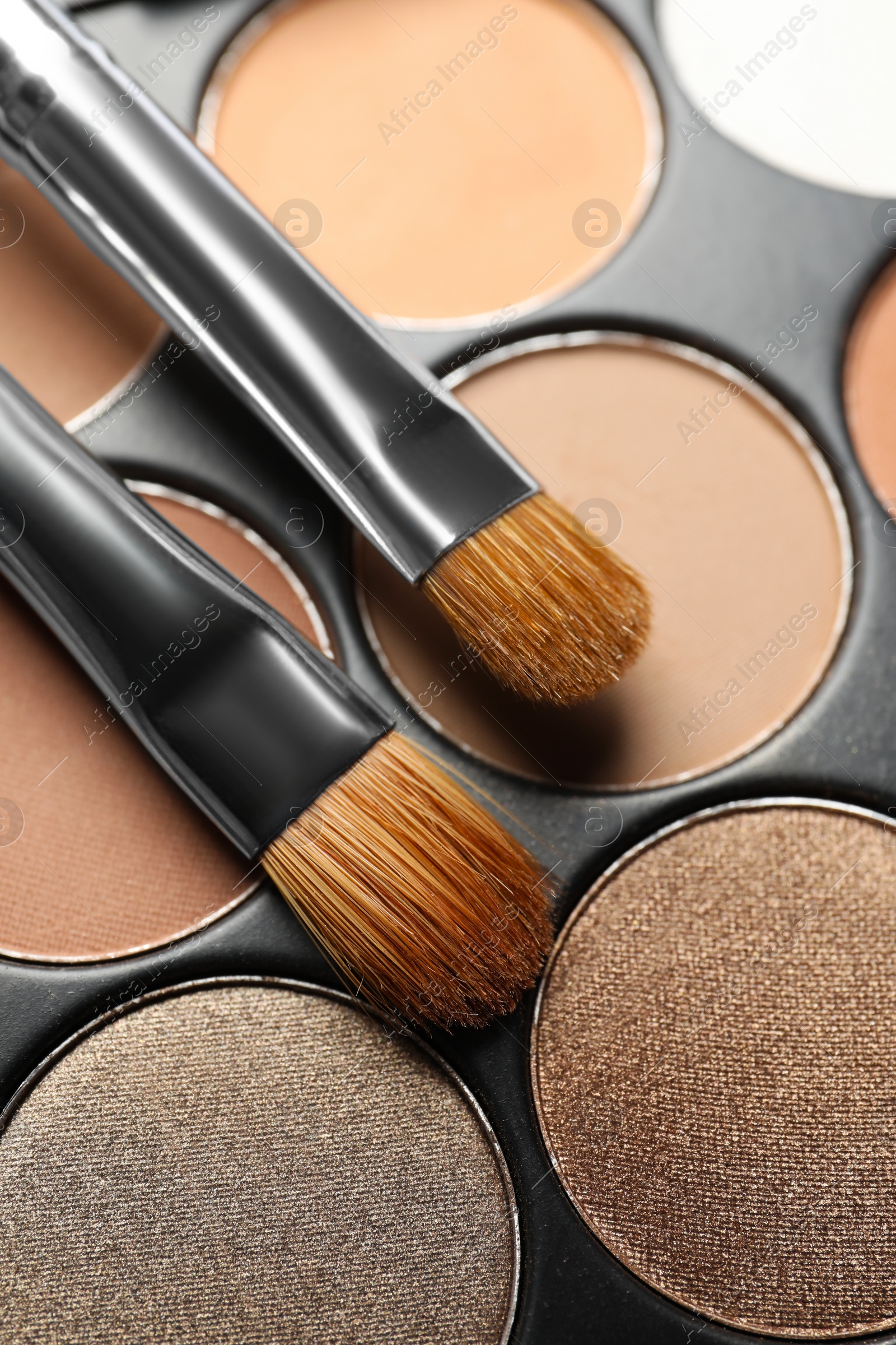 Photo of Beautiful eye shadow palette and brushes as background, above view