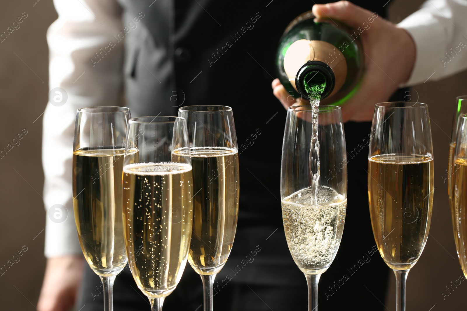 Photo of Waiter pouring champagne into glass, closeup view