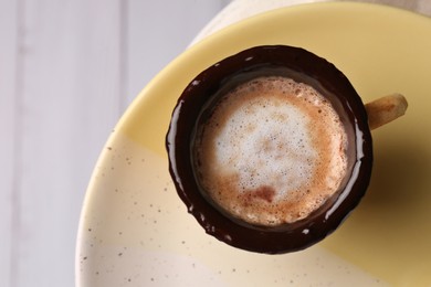Delicious edible biscuit cup with coffee on table, top view
