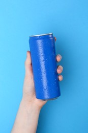 Photo of Woman with energy drink on light blue background, closeup