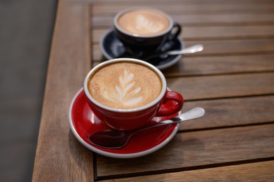 Photo of Cups of aromatic coffee on wooden table