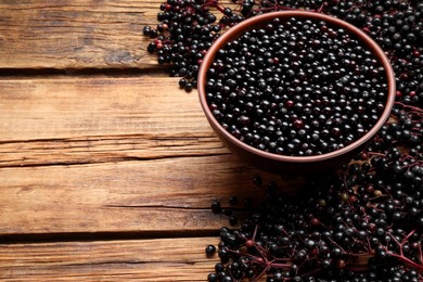 Photo of Elderberries (Sambucus) on wooden table. Space for text