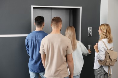 Photo of Group of people waiting for elevator in modern building