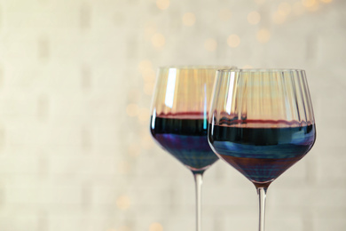 Photo of Glasses of red wine on light background, closeup. Space for text
