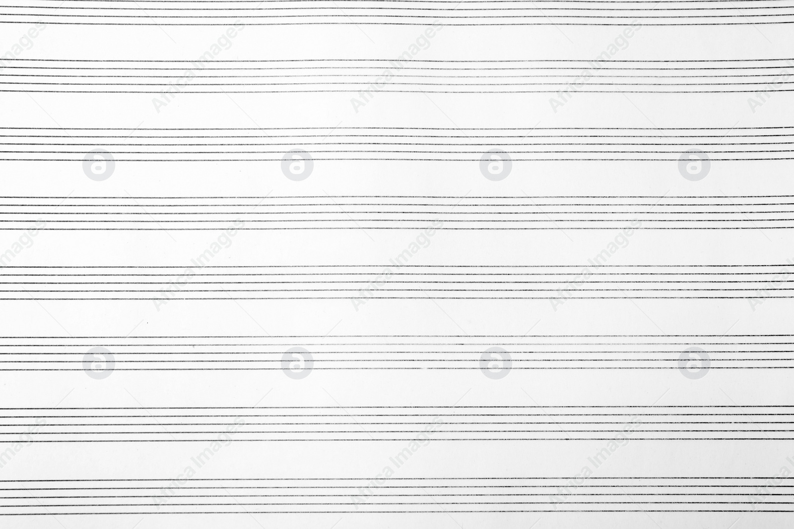 Photo of Paper with empty staves for music notes as background, top view