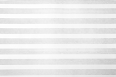 Paper with empty staves for music notes as background, top view