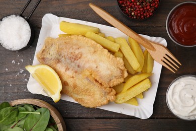 Photo of Delicious fish and chips served on wooden table, flat lay