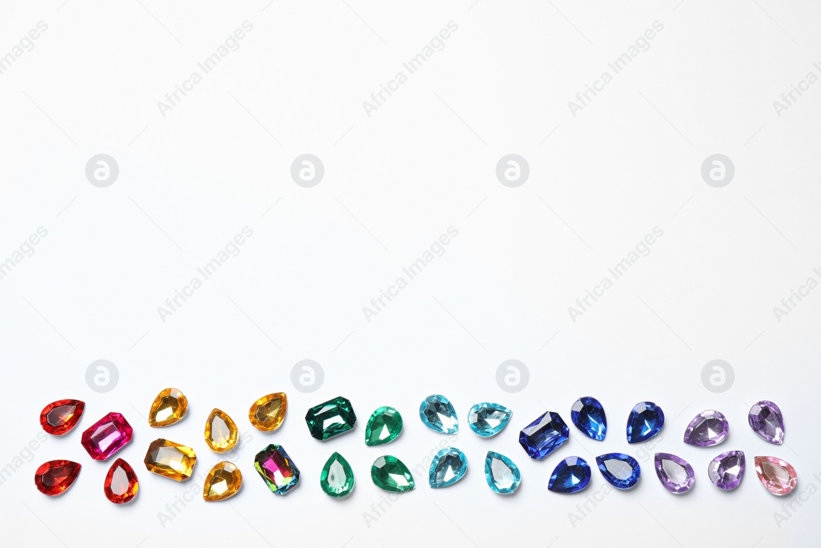 Photo of Different beautiful gemstones on white background, top view