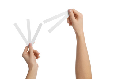 Woman holding perfume testing strips on white background, closeup of hands