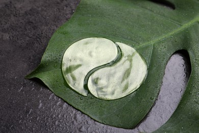 Photo of Under eye patches and tropical leaf on grey wet  background. Cosmetic product