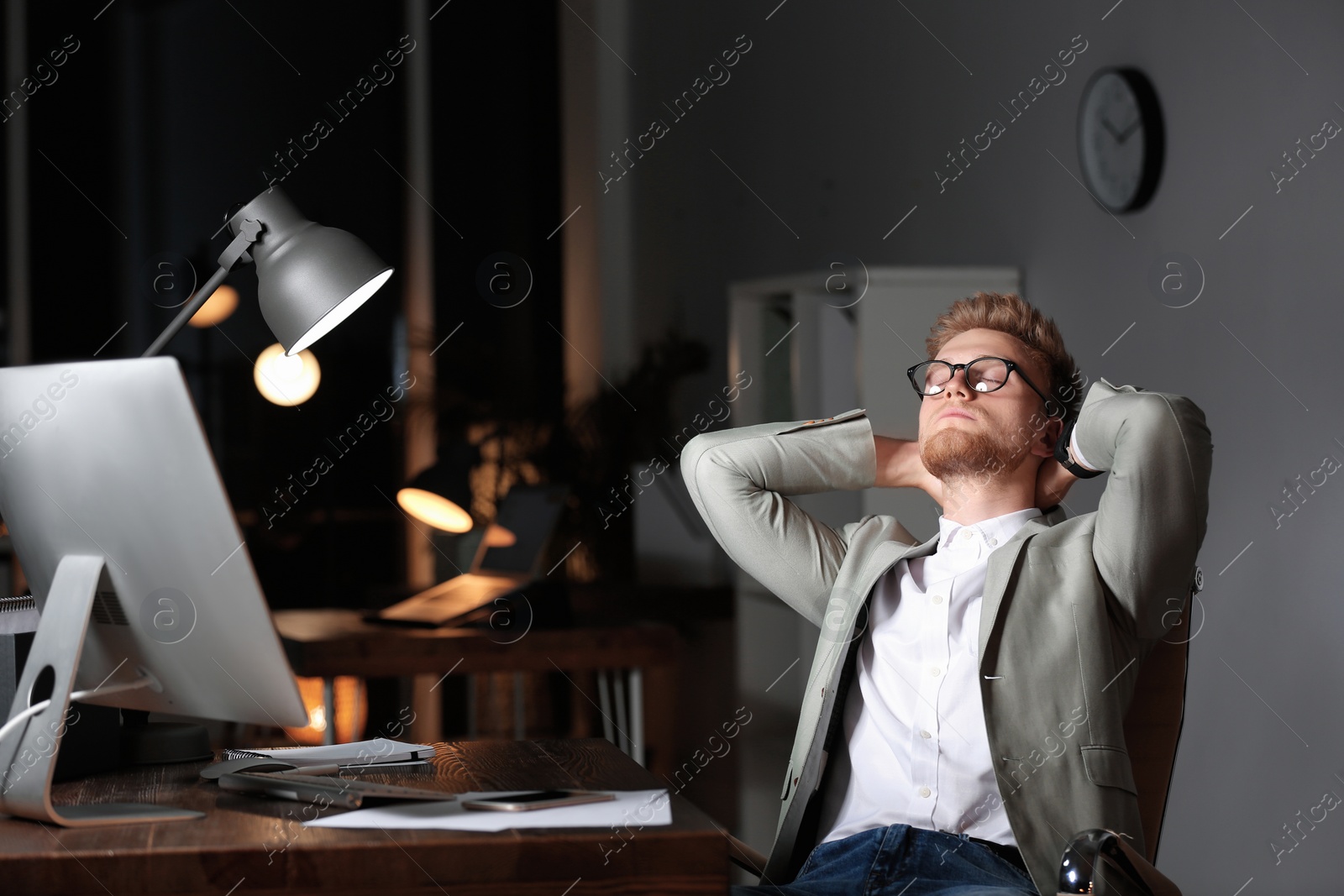 Photo of Tired young businessman working in office alone at night