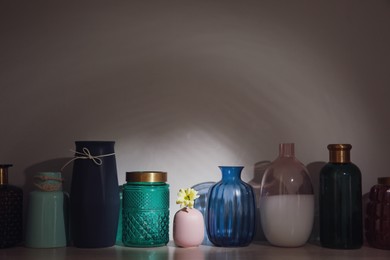 Vase with flower among empty ones on wooden table. Diversity concept