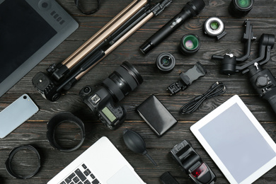 Photo of Flat lay composition with camera and video production equipment on black wooden table
