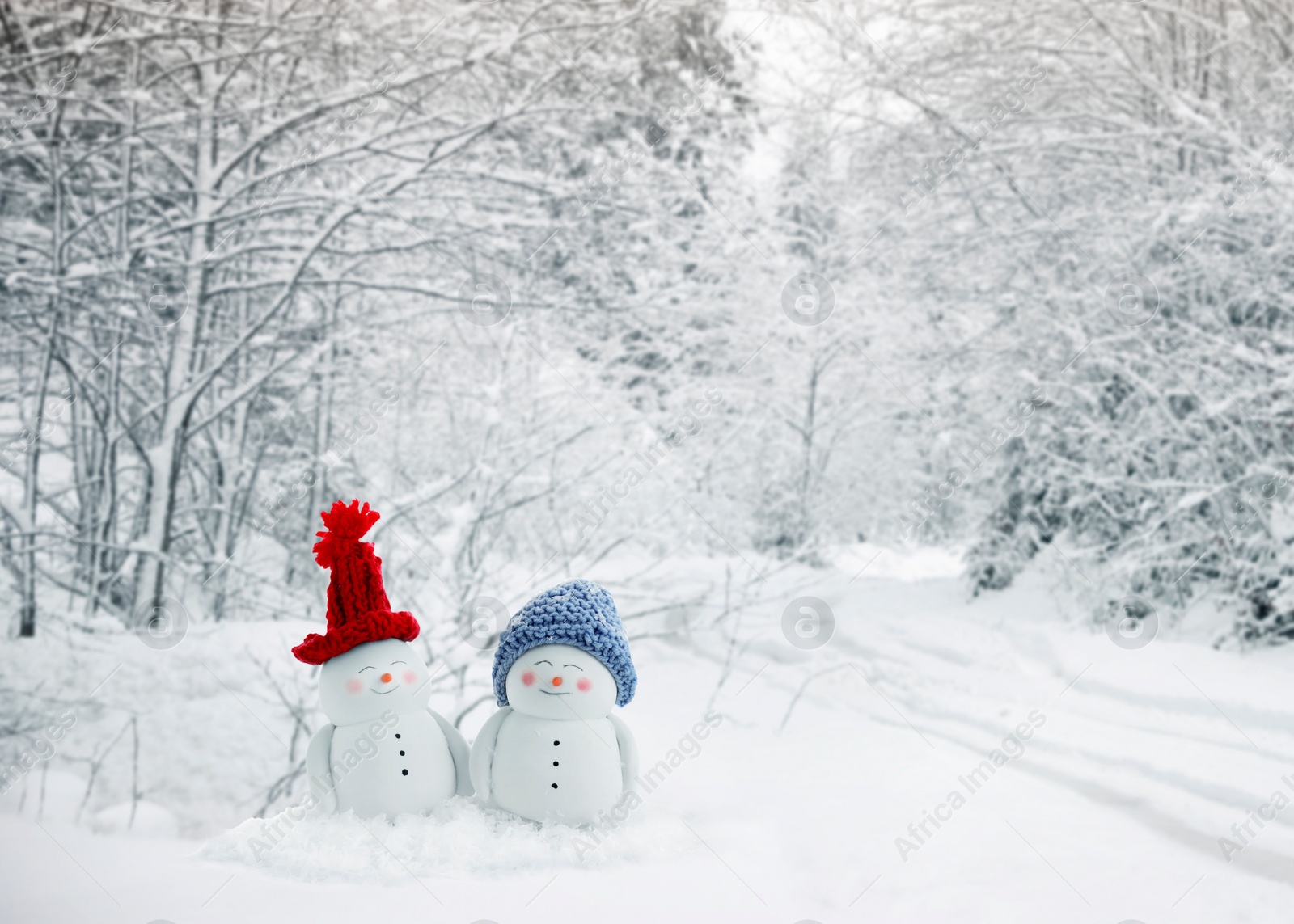 Image of Cute decorative snowmen in snowy forest, space for text