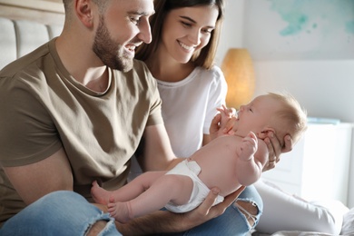 Photo of Happy couple with their newborn baby at home