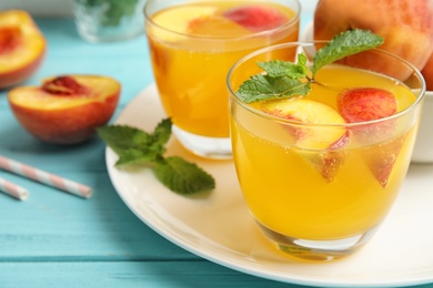 Photo of Tasty peach cocktail in glasses on table. Refreshing drink