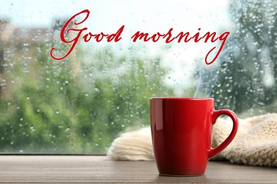 Image of Cup of hot drink and knitted plaid near window on rainy day. Good morning