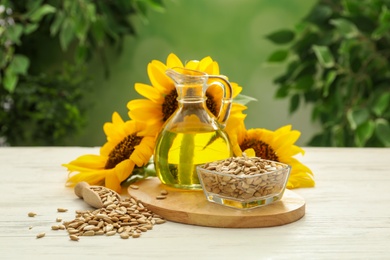 Photo of Composition with sunflower oil on white wooden table against blurred background