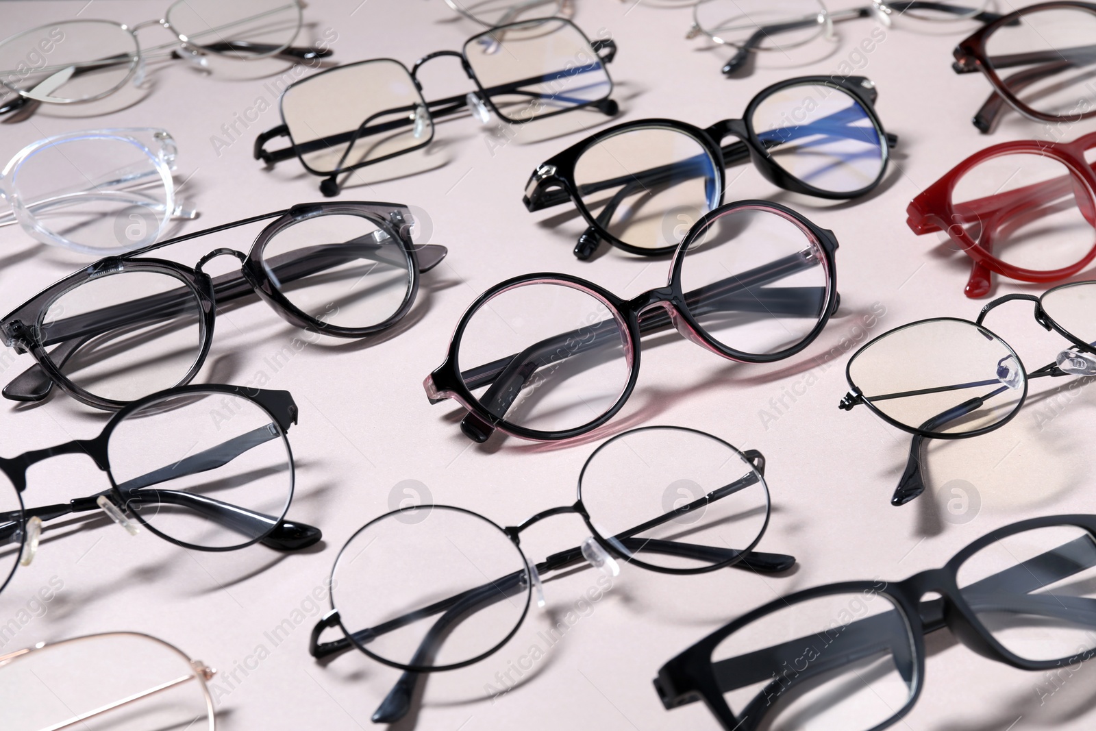 Photo of Many different stylish glasses on light grey background, closeup