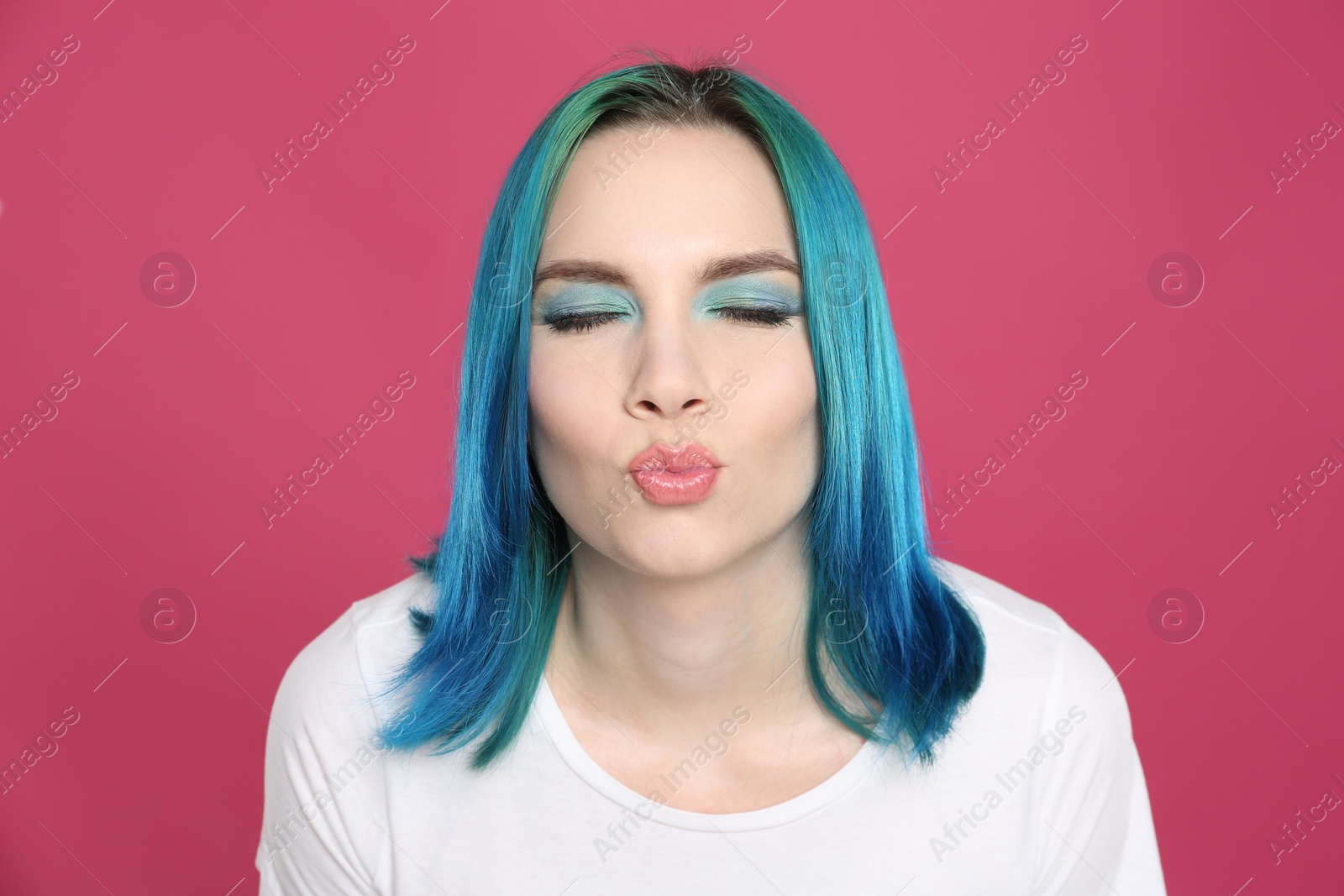 Photo of Young woman with bright dyed hair on pink background