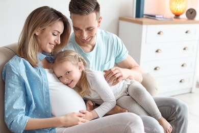 Photo of Young pregnant woman with her family at home