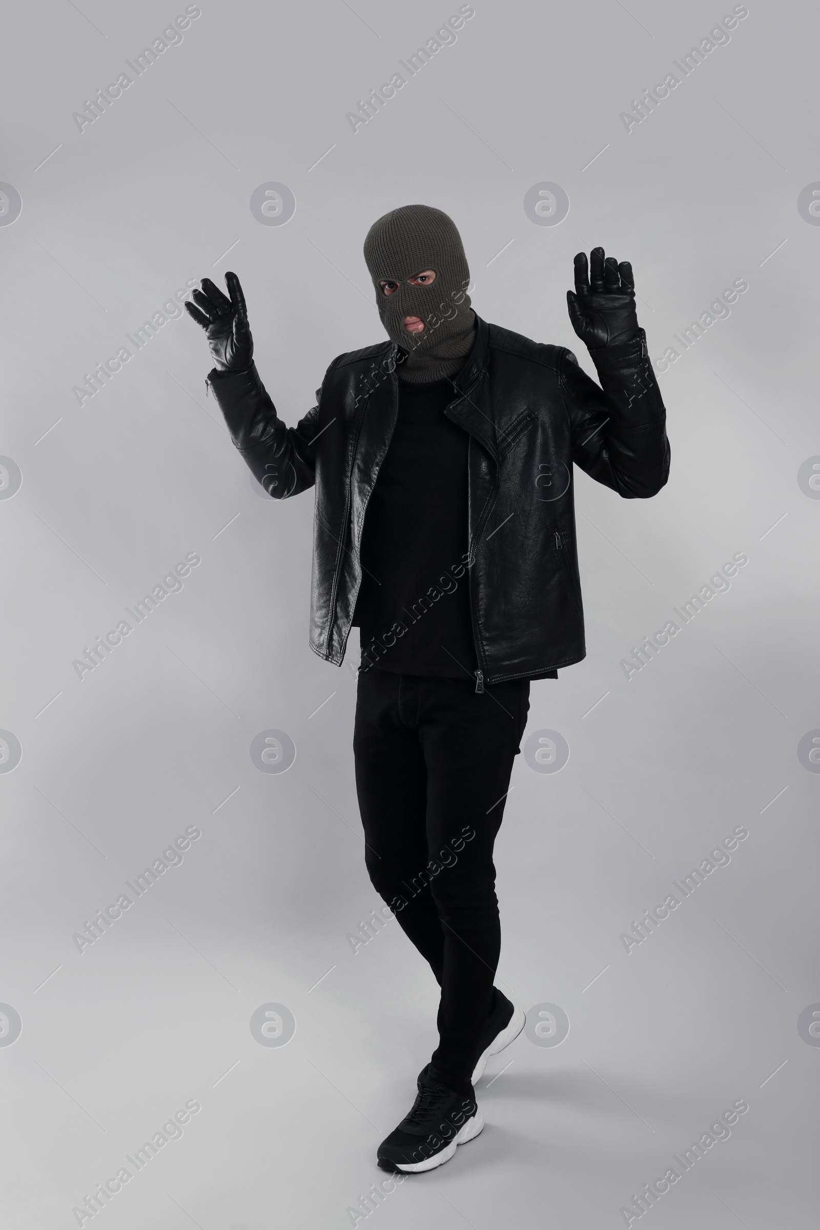 Photo of Man wearing knitted balaclava on light grey background