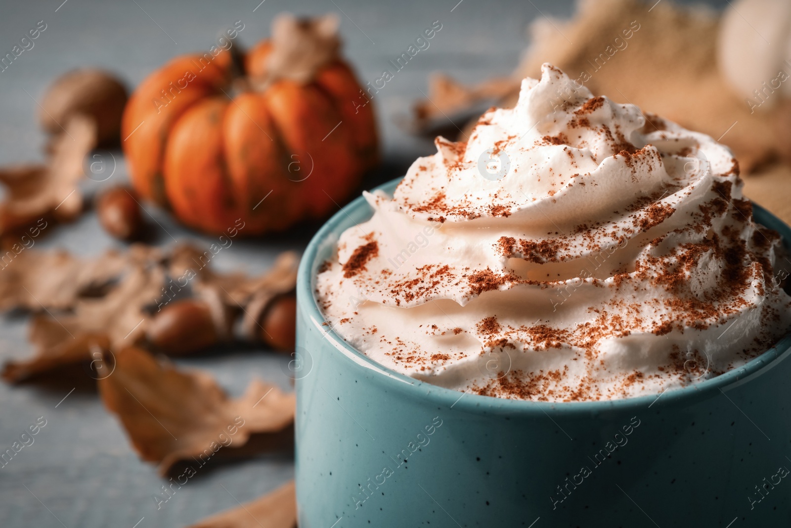 Photo of Delicious pumpkin latte with whipped cream on table, closeup