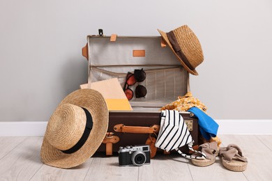 Photo of Clothes, camera and suitcase indoors. Prepare for travel