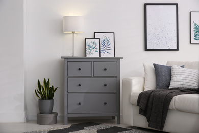 Photo of Modern room interior with grey chest of drawers