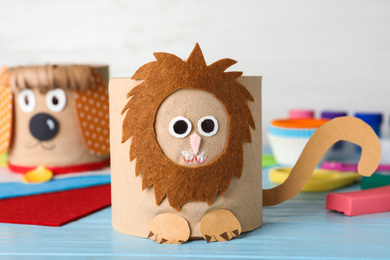 Photo of Toy lion made of toilet paper roll on blue wooden table