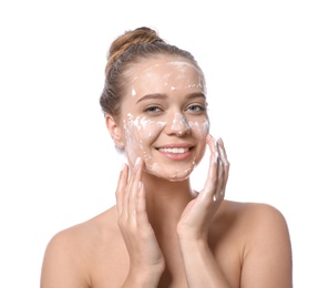 Young woman washing face with soap on white background