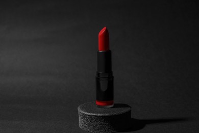 Beautiful glossy red lipstick on black background