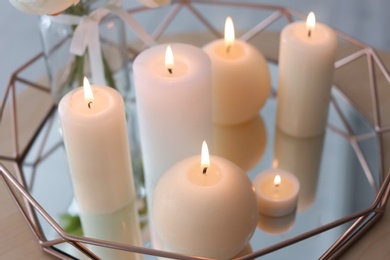 Photo of Burning candles on table, closeup. Interior decor element