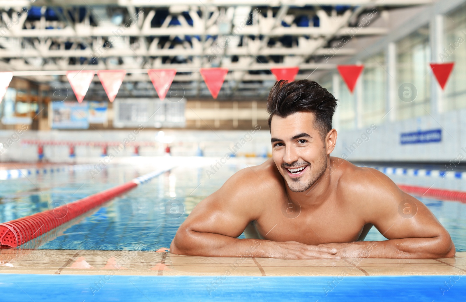 Photo of Young athletic man in swimming pool indoors