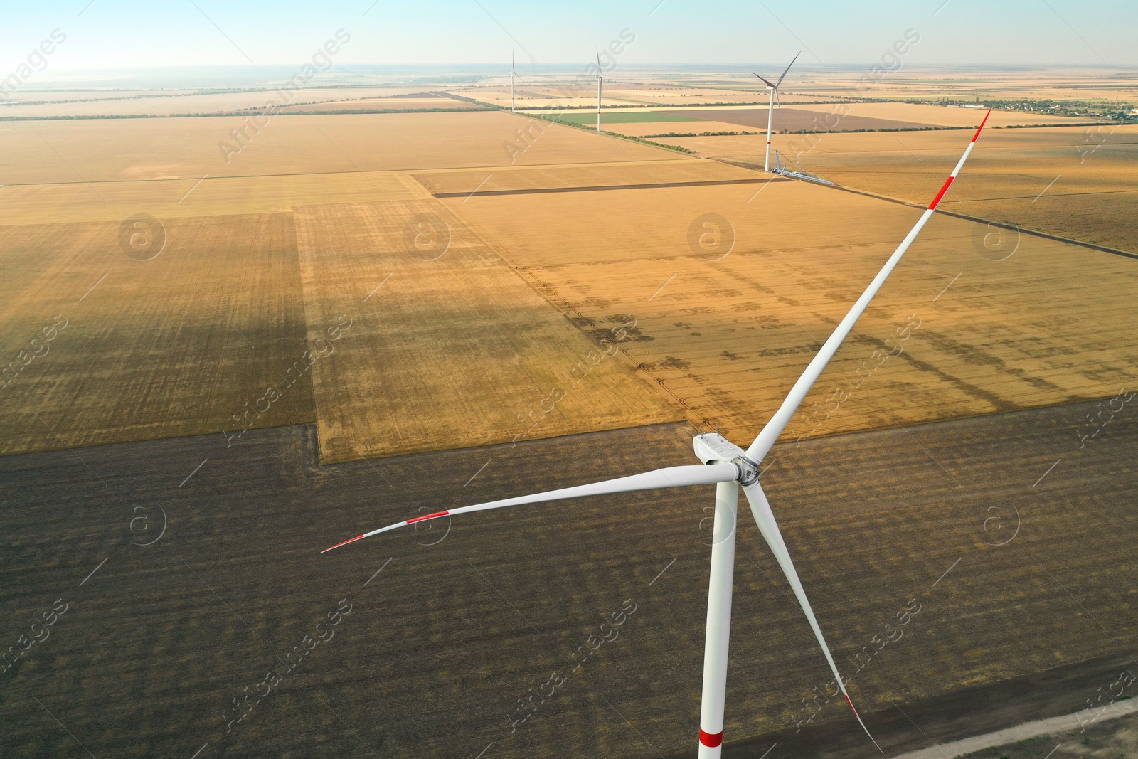 Photo of Modern windmill in wide field. Energy efficiency