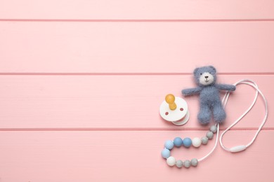 Photo of Cute baby toys and pacifier on pink wooden background, flat lay. Space for text