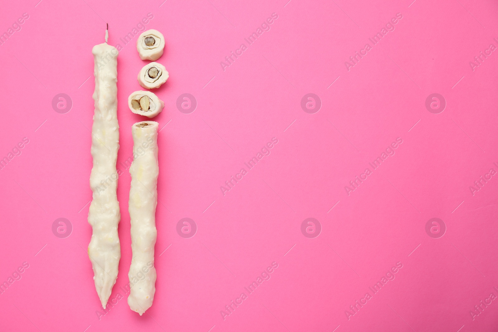 Photo of Delicious churchkhelas on pink background, flat lay. Space for text