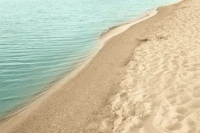 Photo of View of sea water and beach sand on sunny summer day