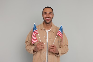 4th of July - Independence Day of USA. Happy man with American flags on light grey background
