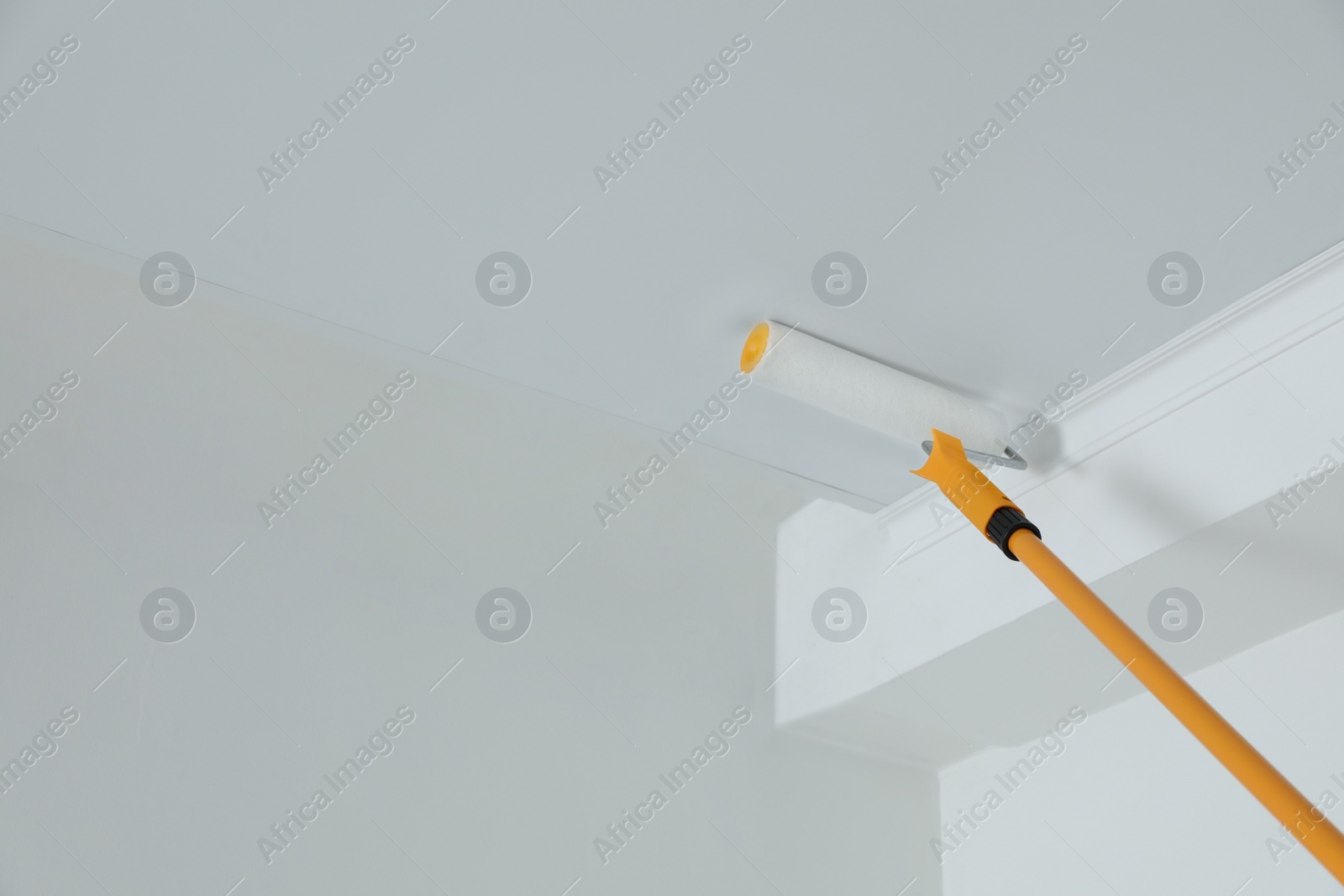 Photo of Painting ceiling with white dye indoors, low angle view. Space for text