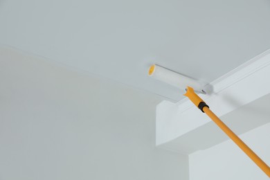 Painting ceiling with white dye indoors, low angle view. Space for text