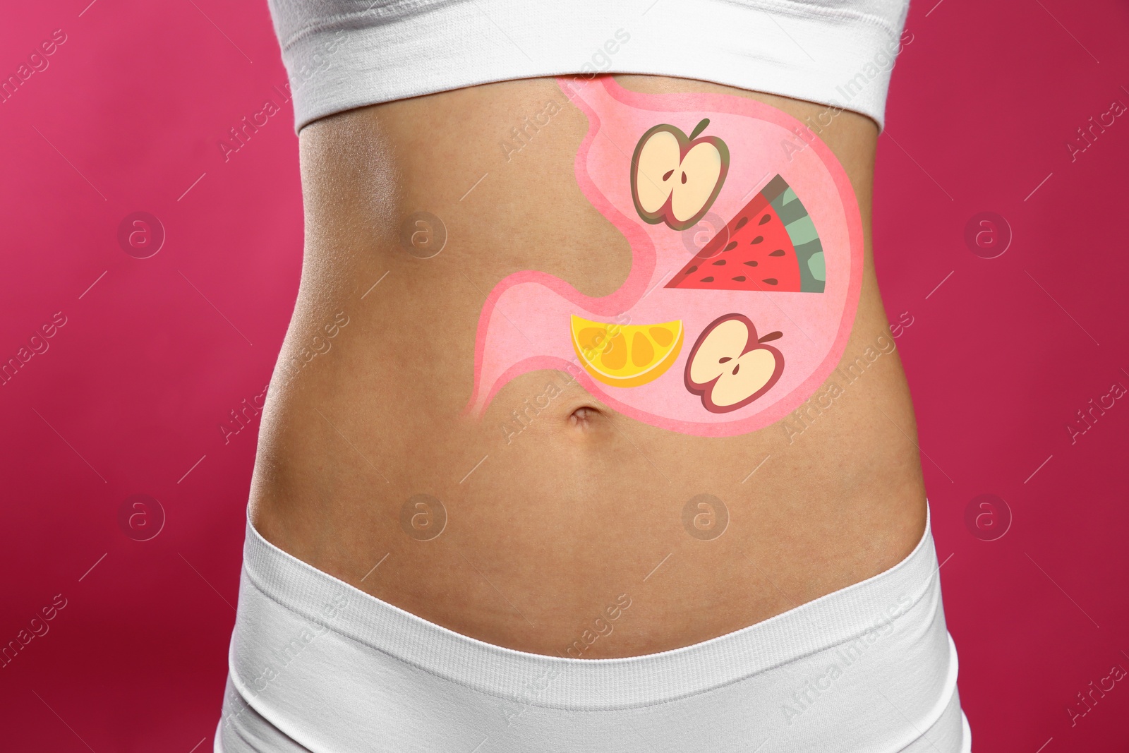 Image of Woman with image of stomach full of food drawn on her belly against pink background, closeup. Healthy eating habits