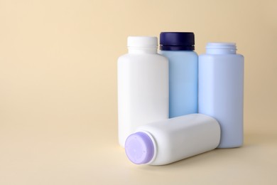 Photo of Baby powder in bottles on beige background. Space for text