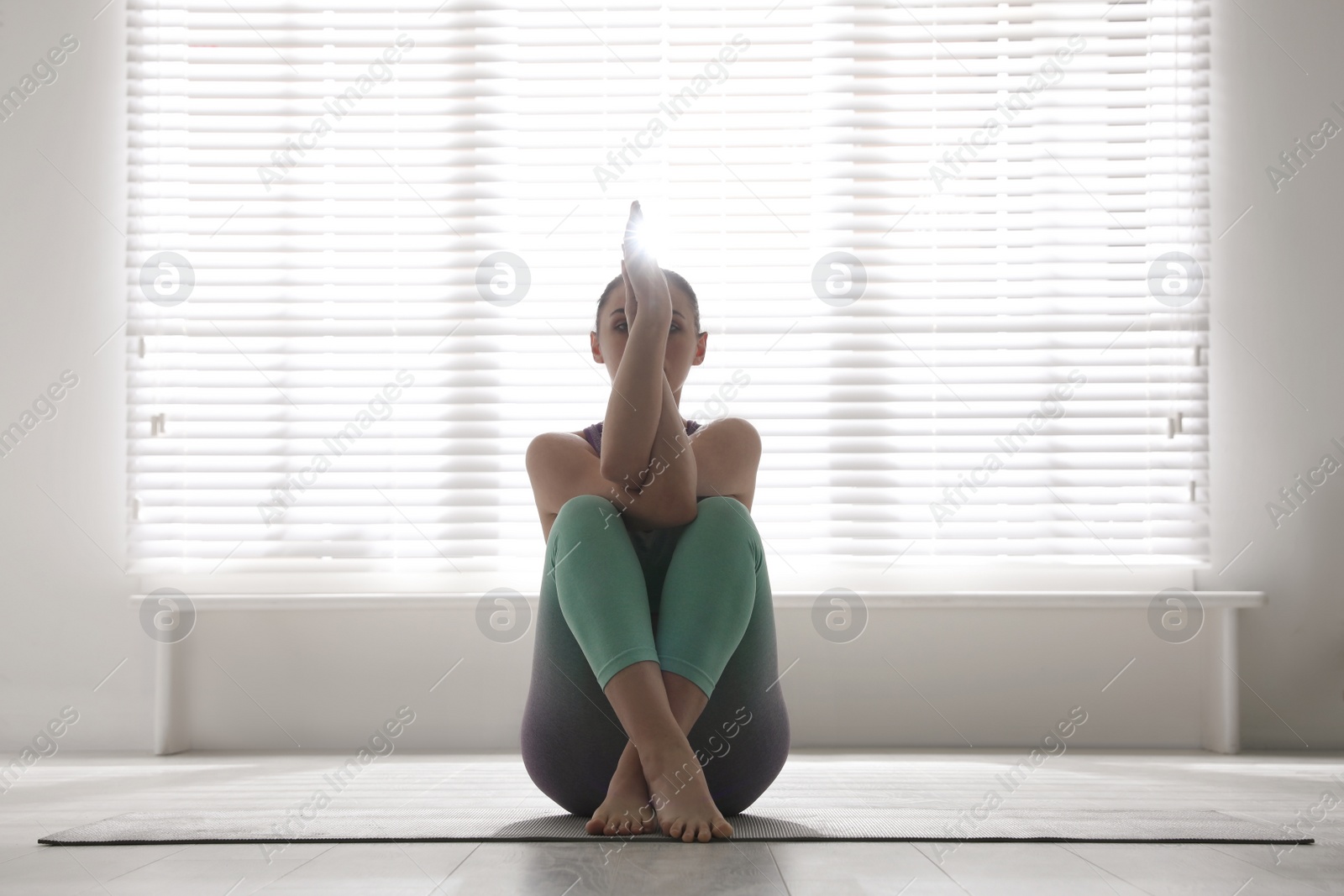 Photo of Woman practicing eagle asana in yoga studio. Garudasana pose