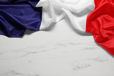 Photo of Flag of France on white marble background, top view. Space for text