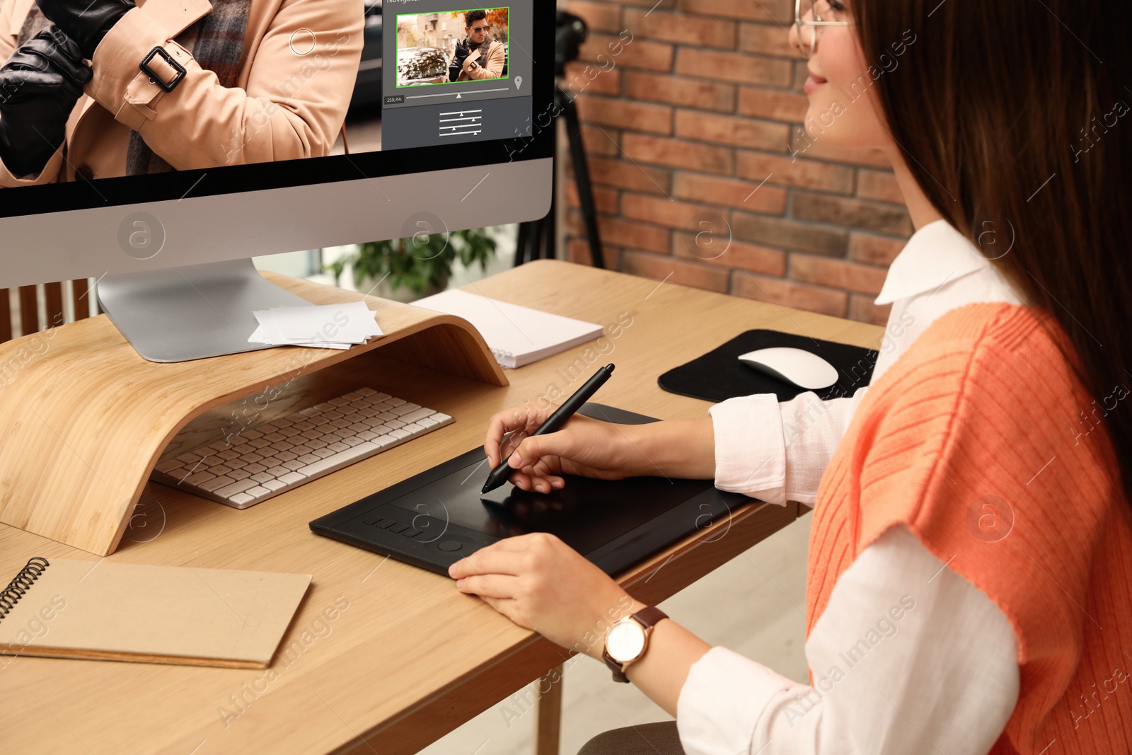 Photo of Professional retoucher working on graphic tablet at desk in office