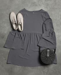 Photo of Stylish dress, shoes and bag on grey stone background, flat lay
