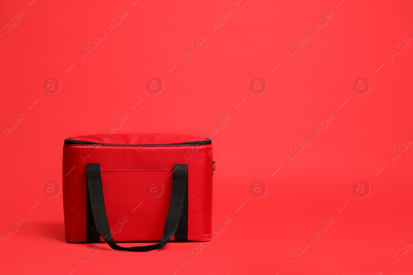 Photo of Modern large thermo bag on red background. Space for text