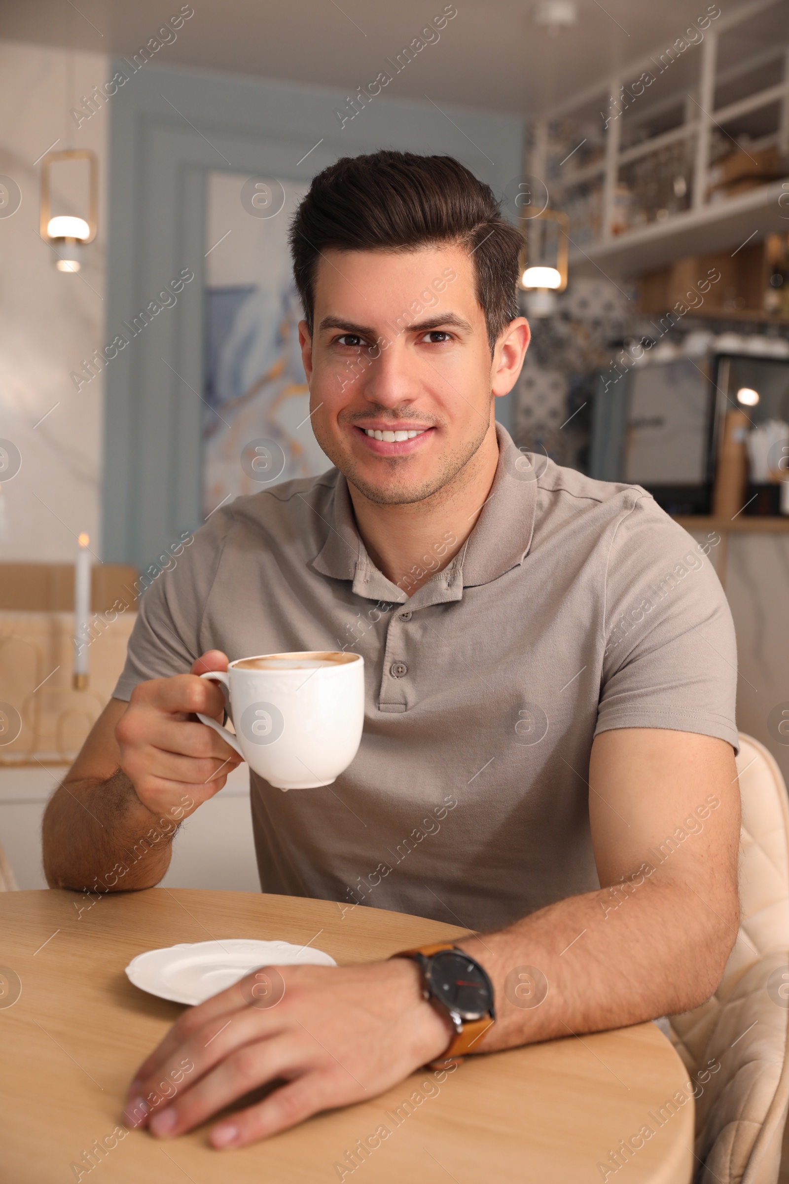 Photo of Man with cup of coffee at cafe in morning