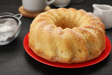 Photo of Delicious freshly baked sponge cake on black table, closeup